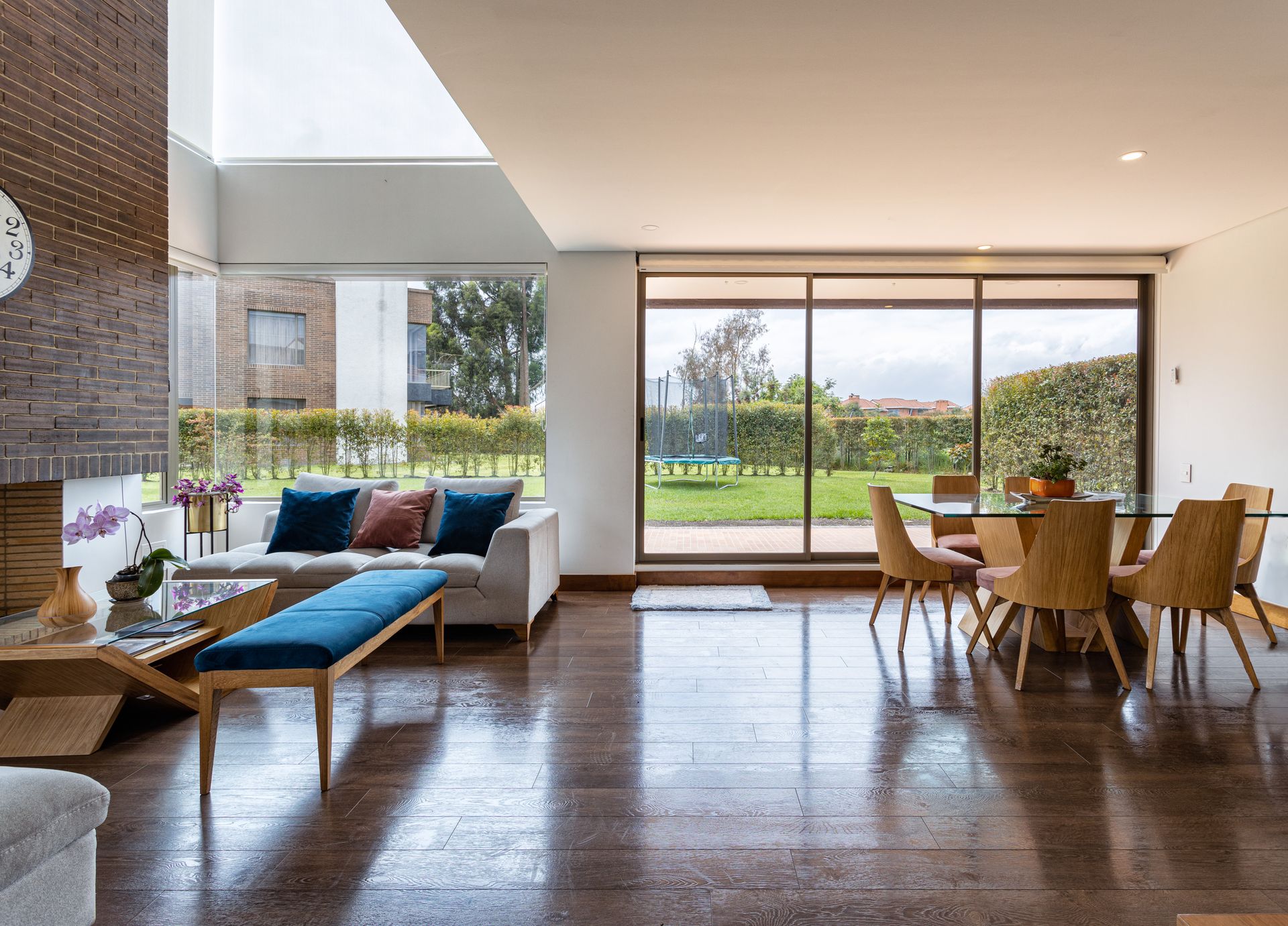 Open-plan villa living space with full-height glazing and concealed lighting