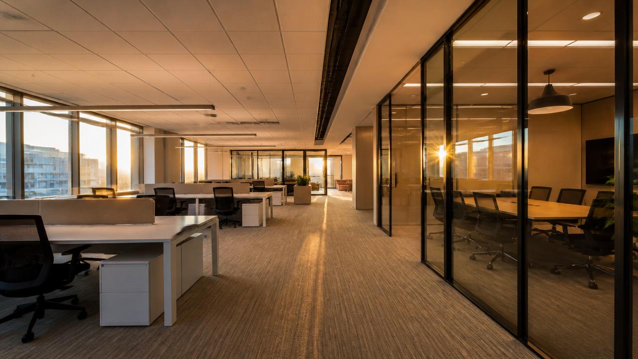 Open-plan office floor with glazed meeting rooms, representing the corporate workplace sector